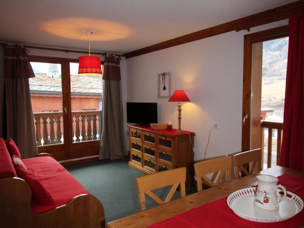 uma sala de estar com uma mesa de jantar e uma televisão em Appartement Lanslebourg-Mont-Cenis, 3 pièces, 6 personnes - FR-1-508-255 em Lanslebourg-Mont-Cenis