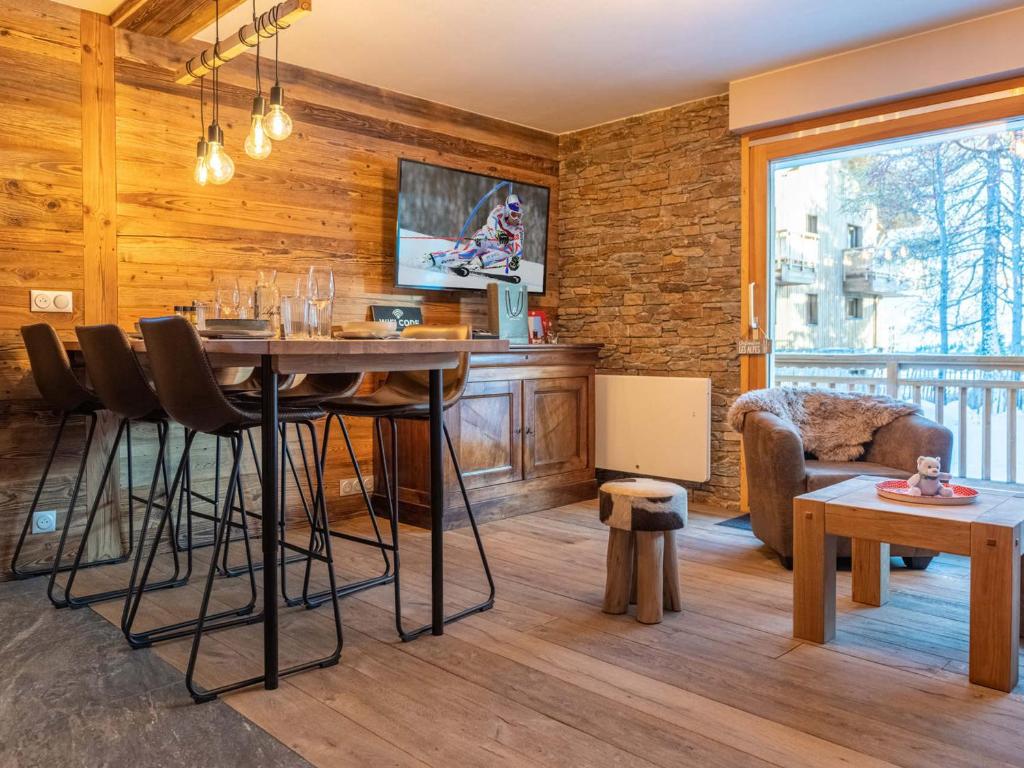a living room with a table and chairs in a room at Appartement rénové au cœur de l'Alpe d'Huez avec Wifi et Parking - FR-1-645-24 in LʼHuez