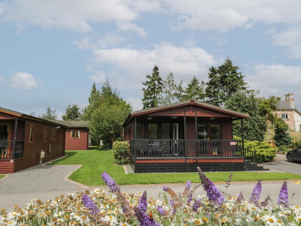 a cabin in a park with purple flowers at Snowdrop in Leominster