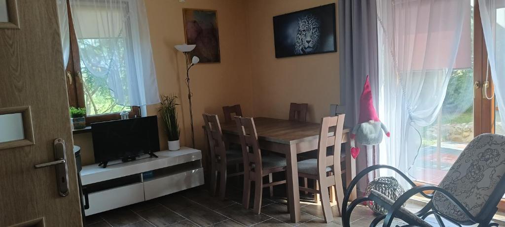 a dining room with a table and chairs and a television at Rajski Azyl in Lidzbark