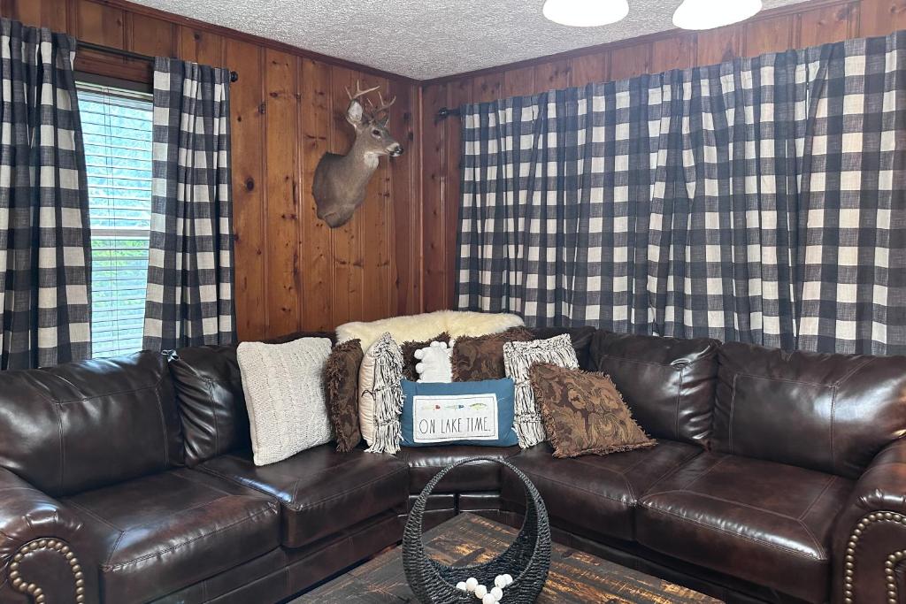 a leather couch in a living room with a deer head on the wall at Bear Crossing in New Tazewell