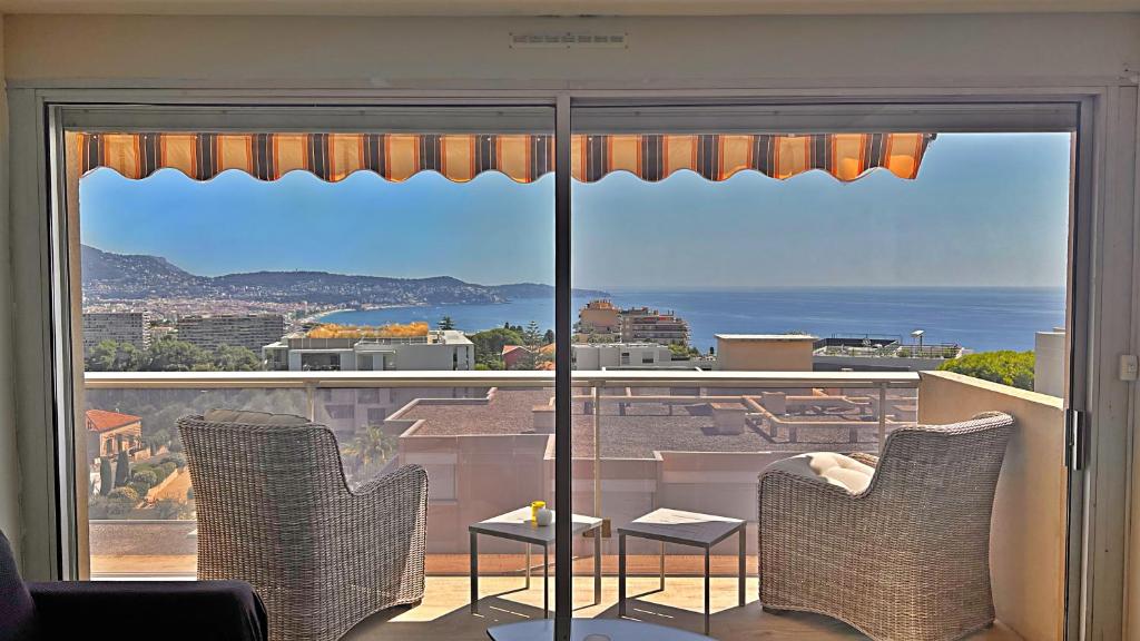 Cette chambre dispose d'une grande fenêtre offrant une vue sur l'océan. dans l'établissement Le Côte et Mer, à Nice