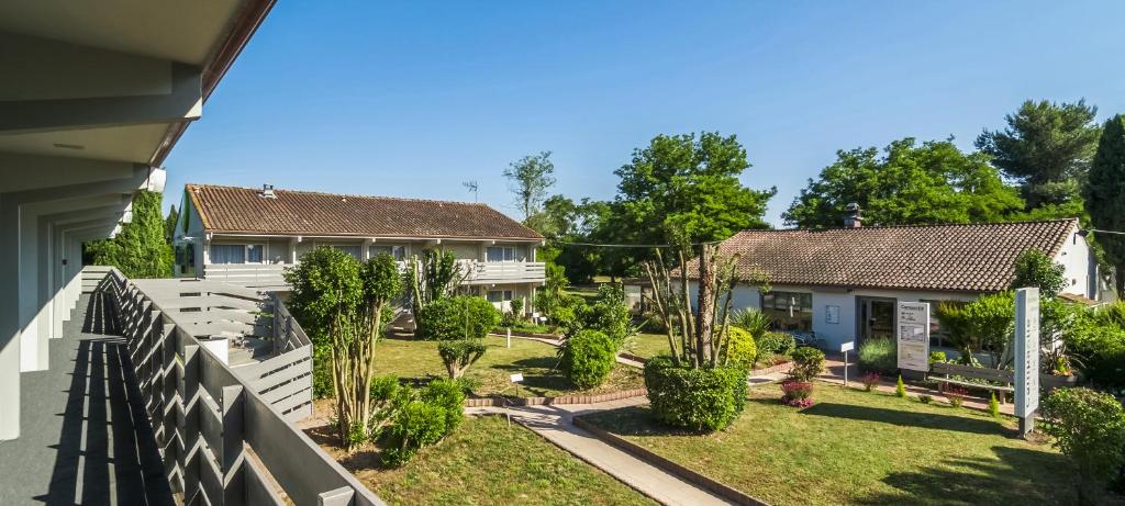 a house with a yard with a fence at Campanile Nîmes Sud - Caissargues in Caissargues