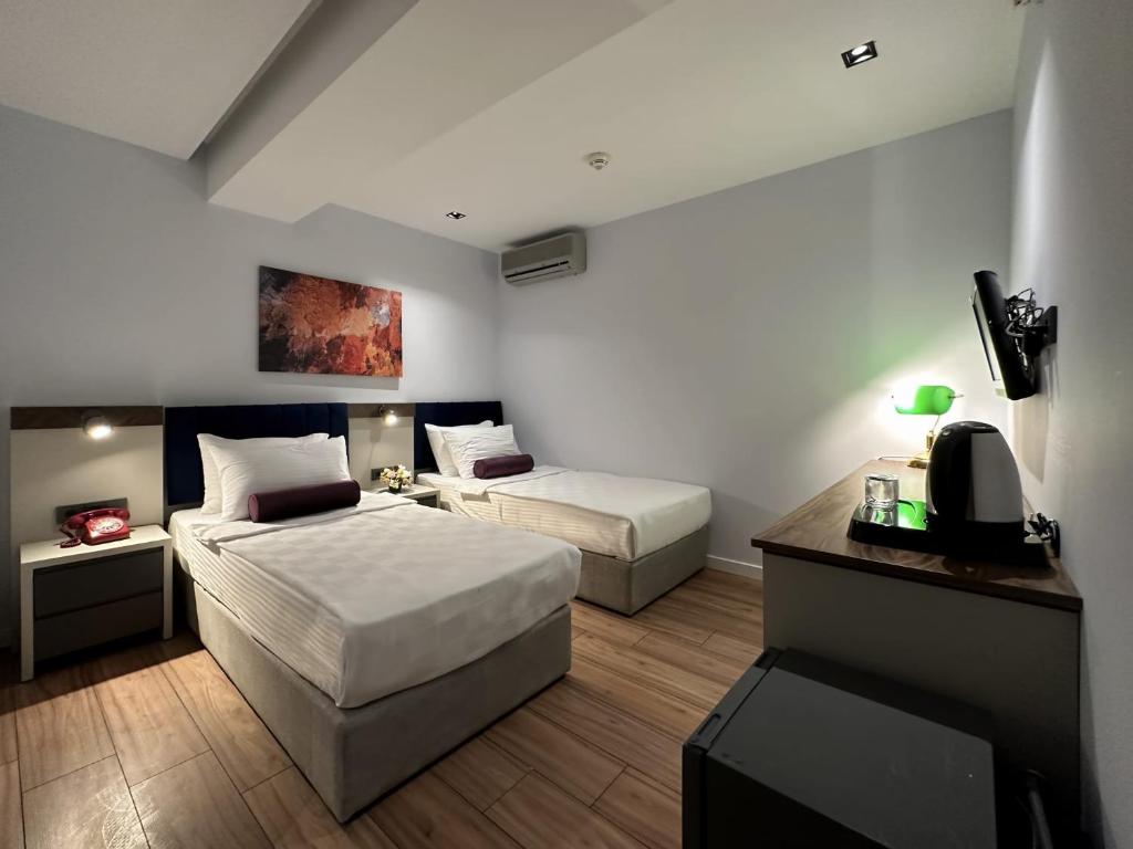 Habitación de hotel con 2 camas y TV en THE ROYALS HOTEL en İzmir