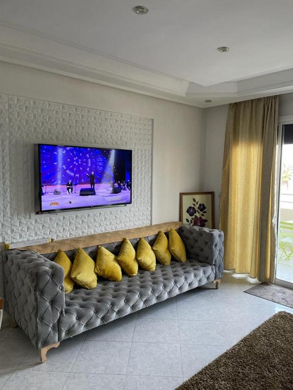 uma sala de estar com um sofá com almofadas amarelas em كوثر em Kenitra