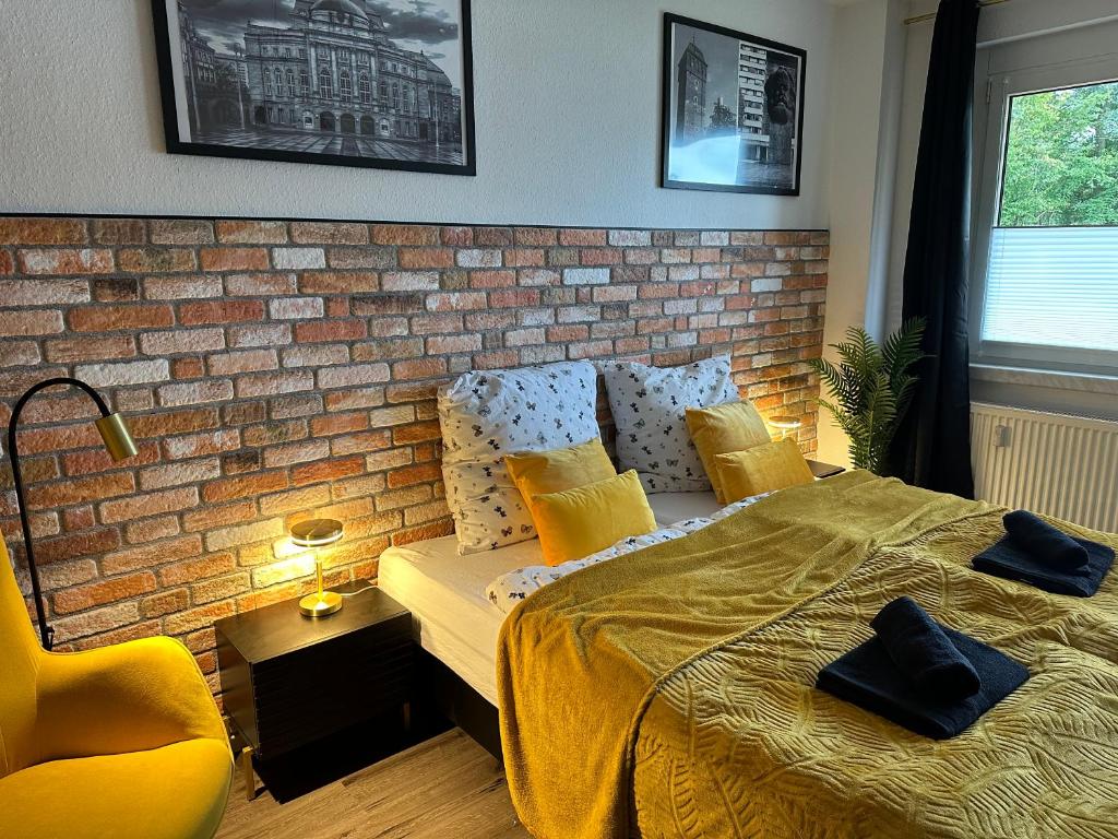 a bedroom with a brick wall and a bed at Moderne Ferienwohnung 5min vom Wasserschloss - Free WIFI & Netflix in Neukirchen
