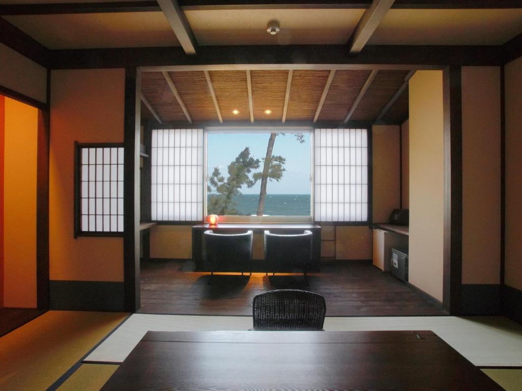 Habitación con mesa, sillas y vistas al océano. en Hamachiyokan - Vacation STAY 56027v en Ise