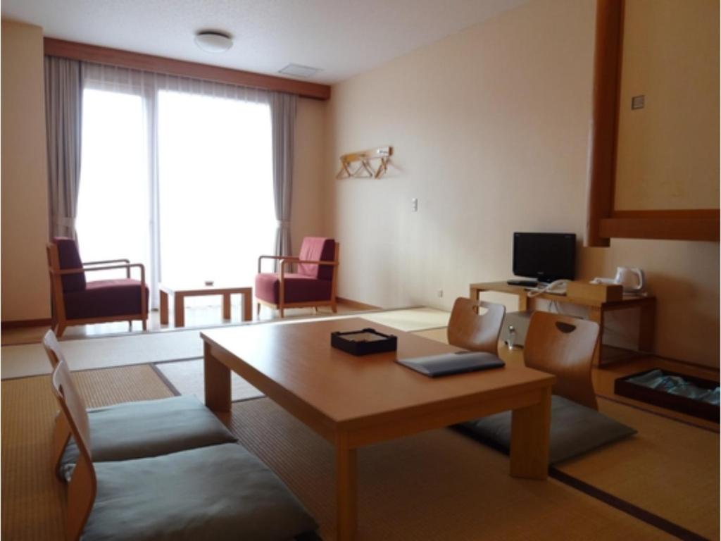 a living room with a wooden table and chairs at Bokkai Onsen Seaside Villa Bokkai - Vacation STAY 69006v in Shika