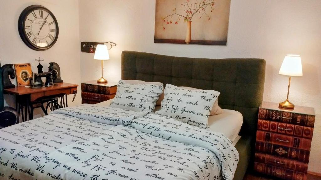 a bedroom with a bed and a clock on the wall at Honey house Lika in Gospić