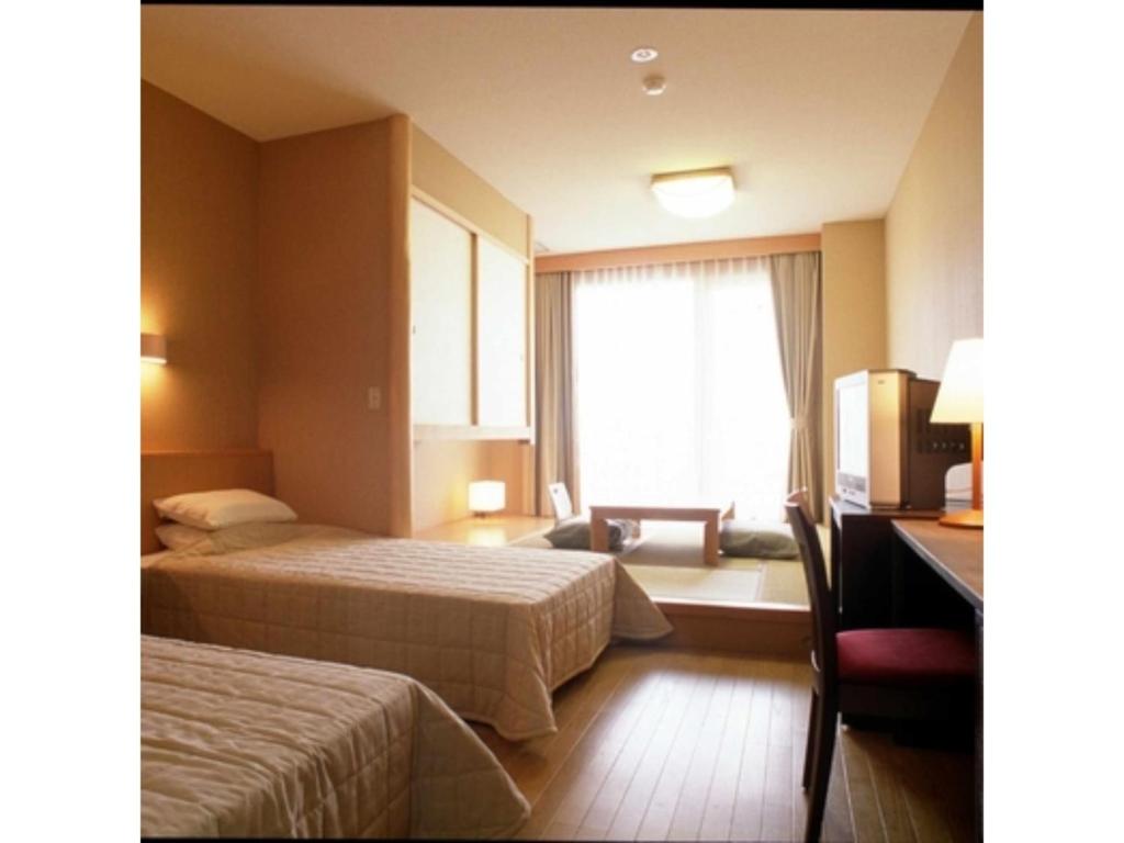 a hotel room with two beds and a window at Bokkai Onsen Seaside Villa Bokkai - Vacation STAY 69023v in Shika