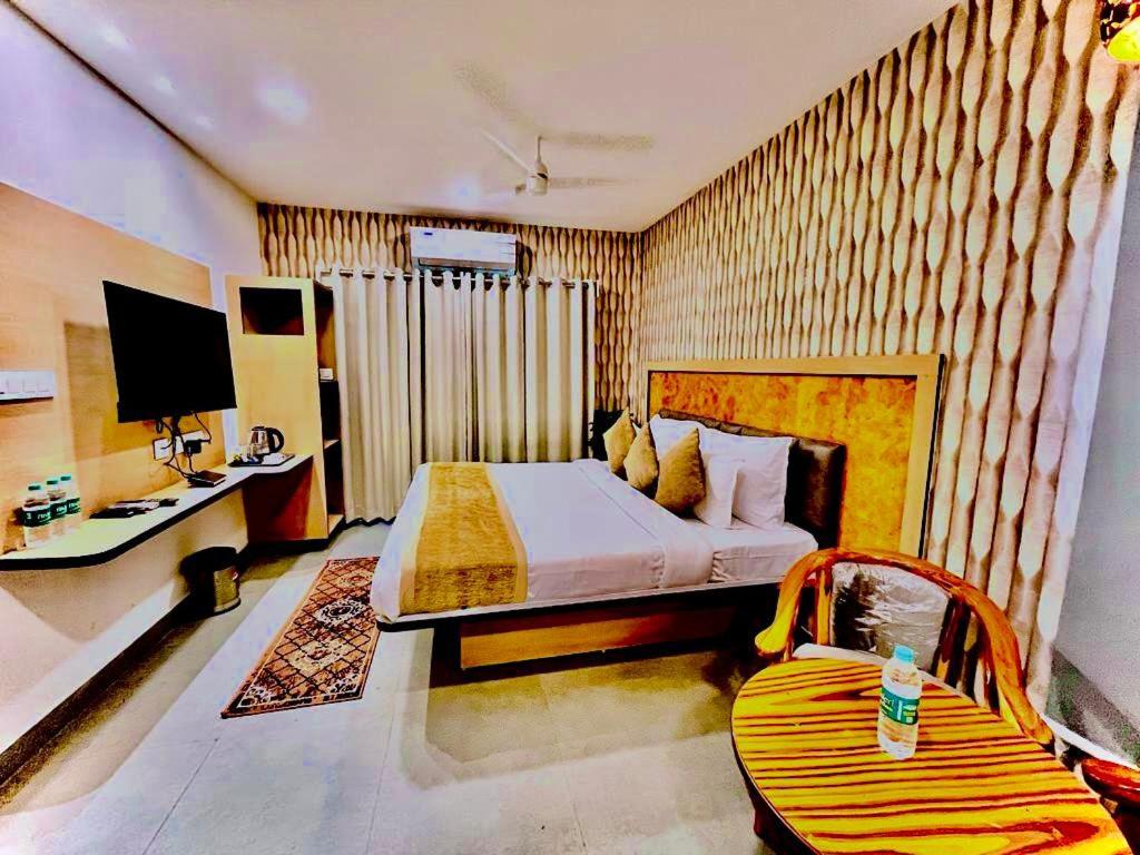 a bedroom with a bed and a chair in it at Hotel Lake View Airport zone in Hyderabad
