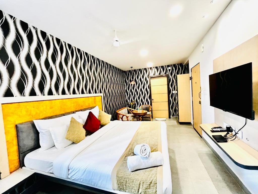 um quarto com uma cama grande e uma televisão em Hotel Lake View Airport zone em Hyderabad