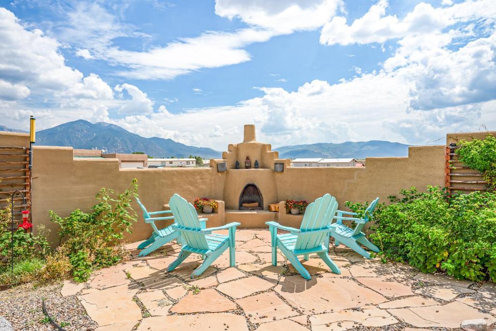 two blue chairs sitting in front of a house at Casa del Sol Naciente in El Prado