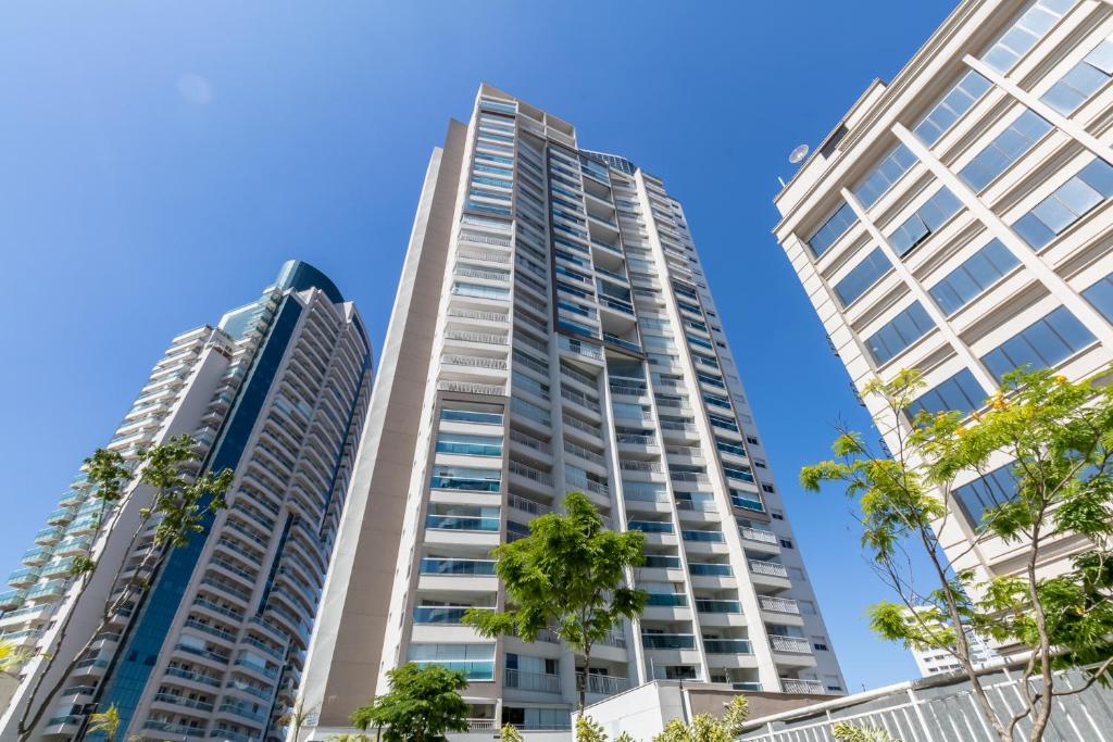 deux grands bâtiments dans une ville bordée de palmiers dans l'établissement 360 Summit Pinheiros, à São Paulo