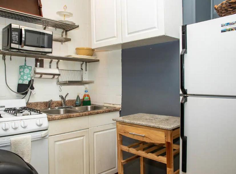 cocina con nevera blanca y fregadero en Marvelous 3BR in NYC! en Nueva York