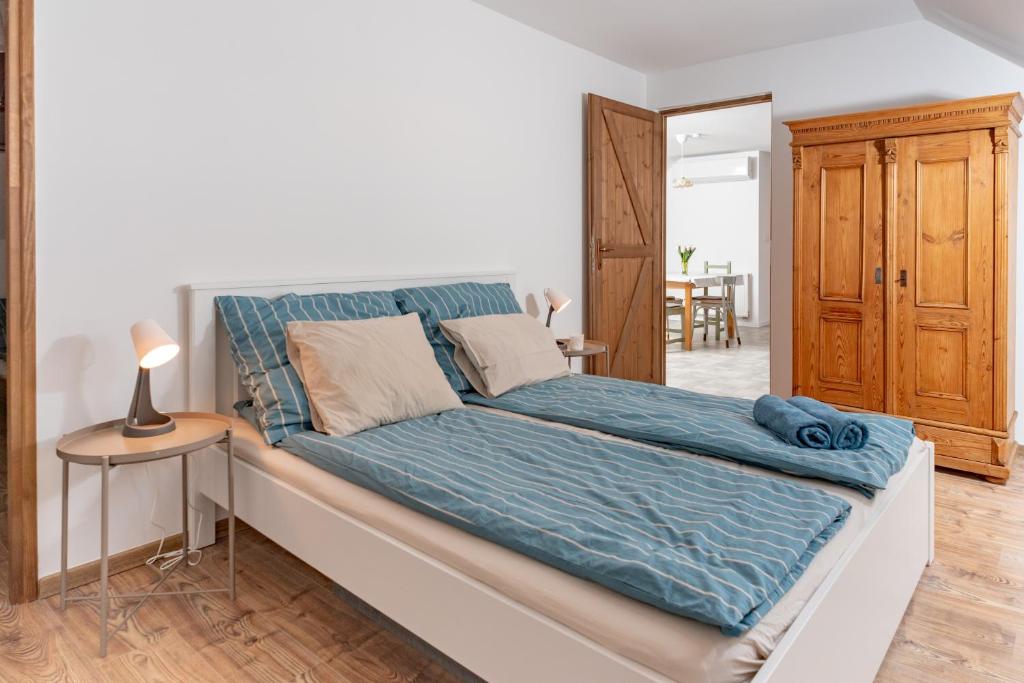 1 dormitorio con 1 cama grande con sábanas azules en Berkenyeliget Vendégház en Szigliget