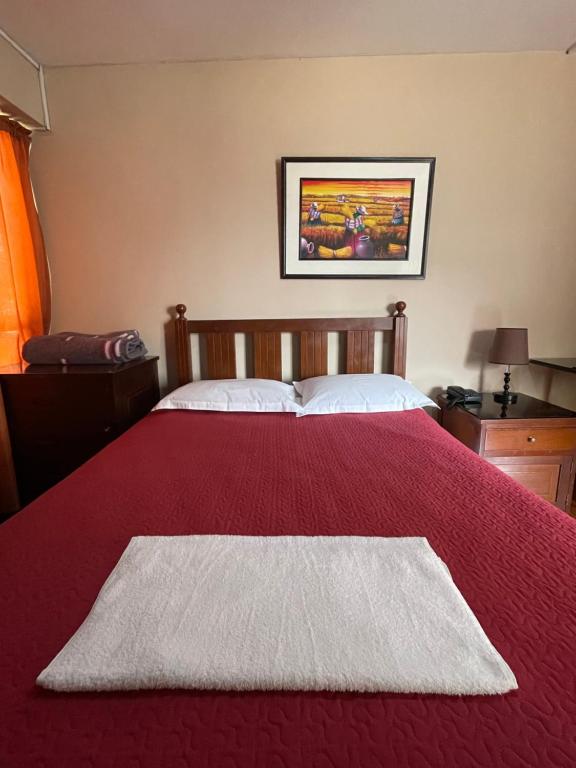 a bedroom with a red bed with a red blanket at Wenhy’s Inn in Lima