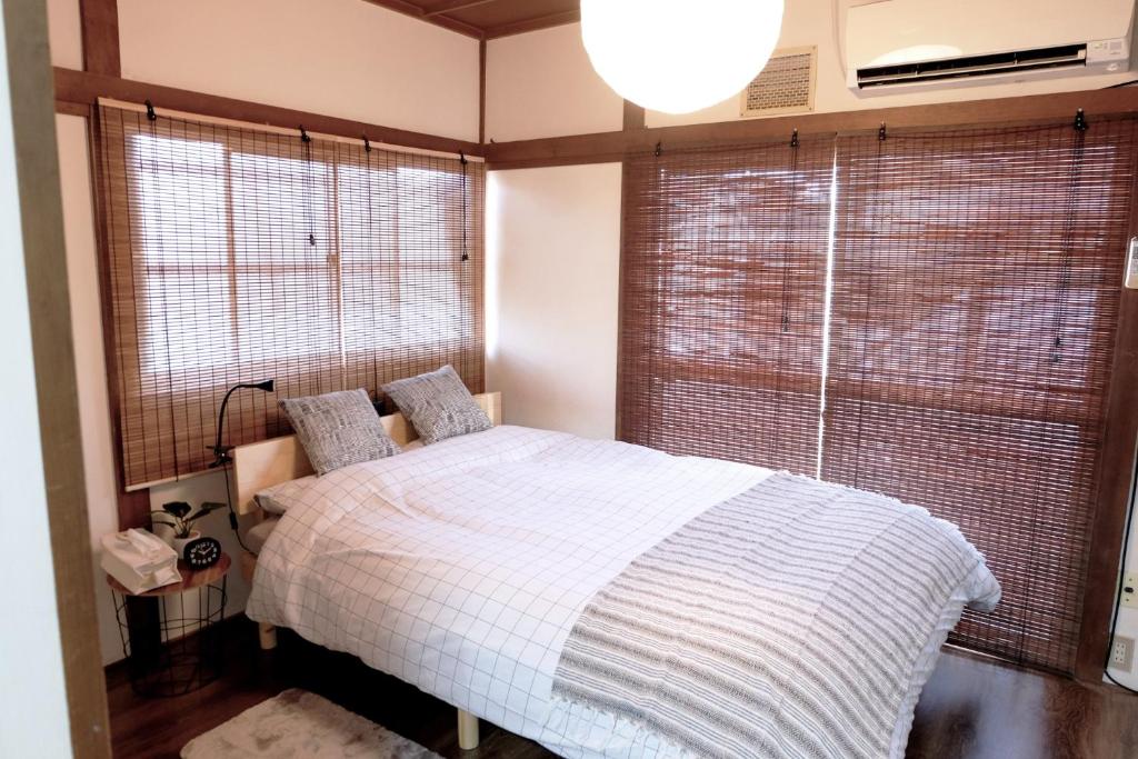 1 dormitorio con cama y ventana grande en Daiichi Mitsumi Corporation - Vacation STAY 15266, en Musashino