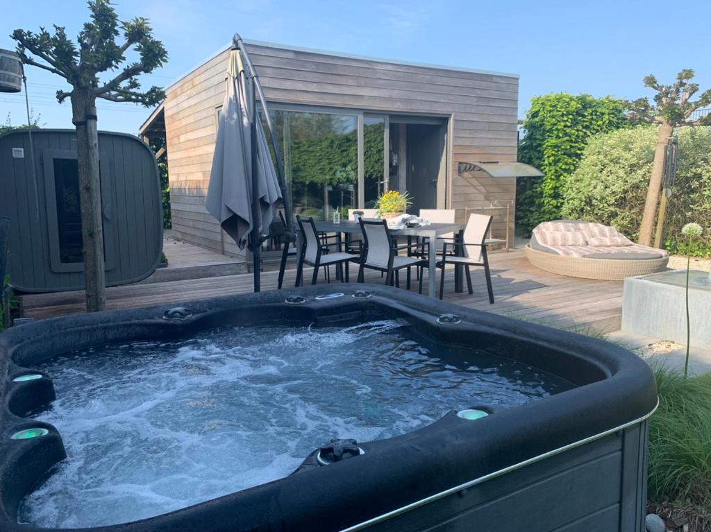 a hot tub in a backyard with a table and chairs at La chambre du puits avec 2 jacuzzis , sauna et Hammam privatif in Tournai