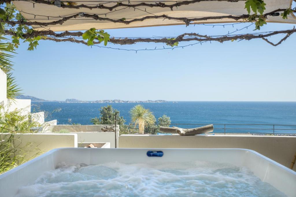 une baignoire jacuzzi sur le balcon d'une maison dans l'établissement LES SUITES LOVE 3 SPA VUE MER PISCINe, à Marseille