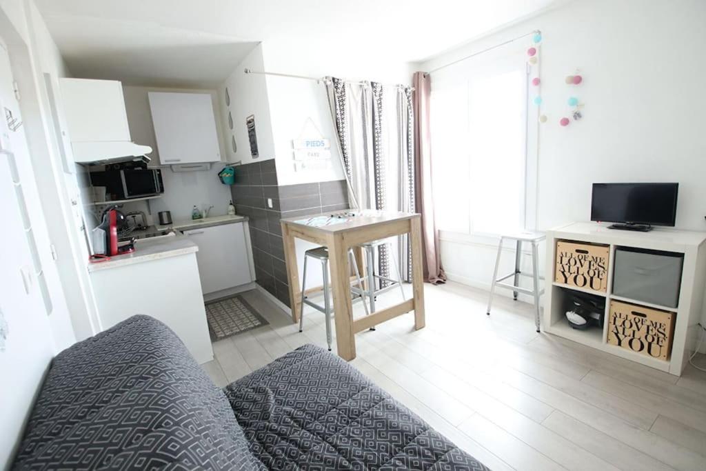 un salon avec un canapé et une cuisine dans l'établissement Joli studio à 3 min de la plage - rénové en avril 2025, à Royan