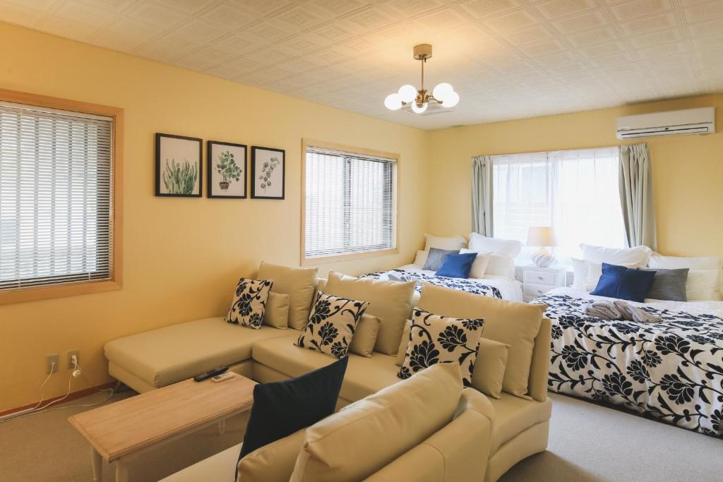 a living room with two beds and a couch at Kamenoko House - Vacation STAY 15285 in Kadena