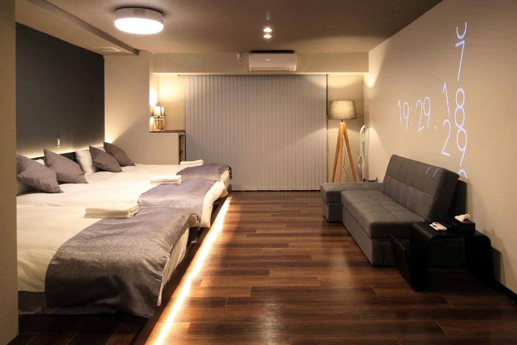 Cette chambre comprend 4 lits et un canapé. dans l'établissement Precioso Umeda - Vacation STAY 15185, à Osaka