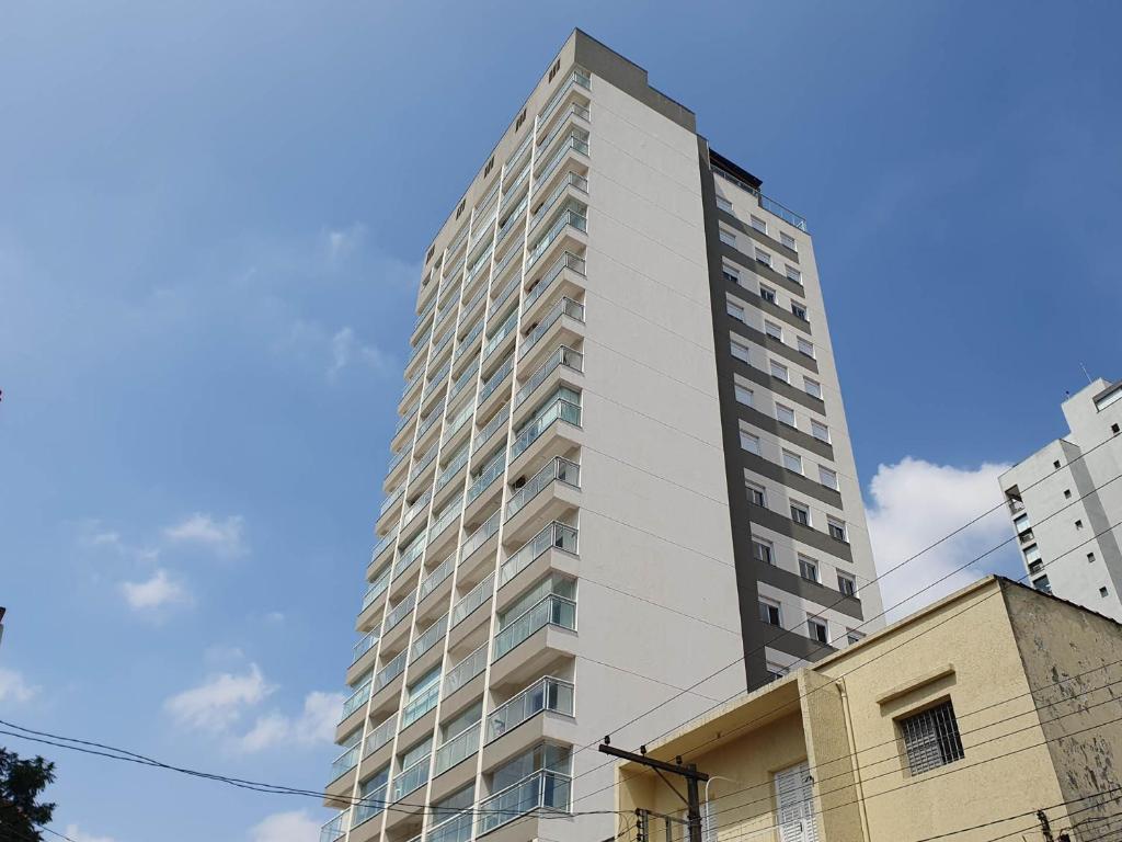 ein hohes weißes Gebäude mit blauem Himmel im Hintergrund in der Unterkunft 360 Praça da Árvore in São Paulo