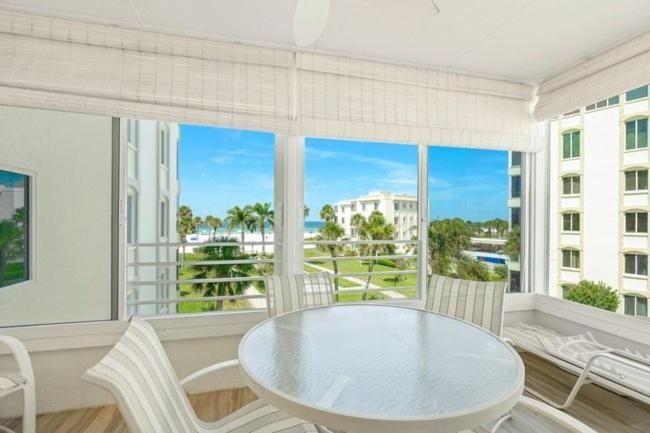 a table and chairs in a room with a large window at Island House Beach Resort 14S in Point O'Rocks