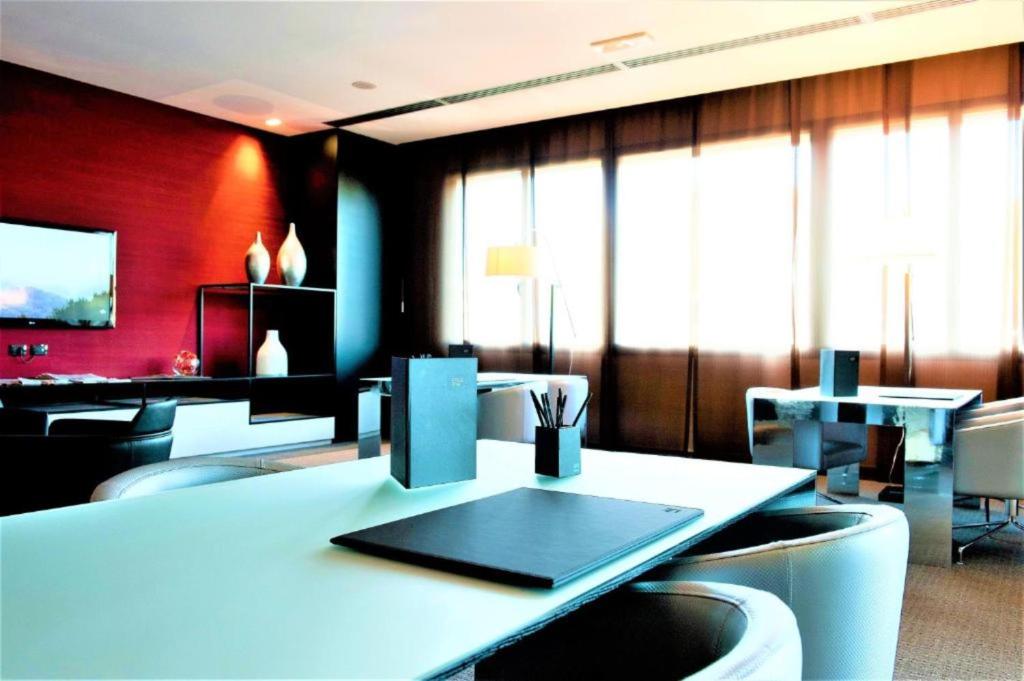 パドヴァにあるAC ホテル パドヴァ ア マリオット ライフスタイル ホテルのテーブル、椅子、テーブルが備わる客室です。