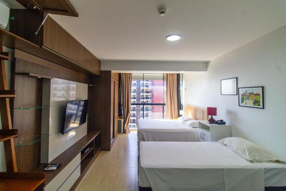 a hotel room with two beds and a flat screen tv at Garvey Park Hotel - Apartamento Particular in Brasilia