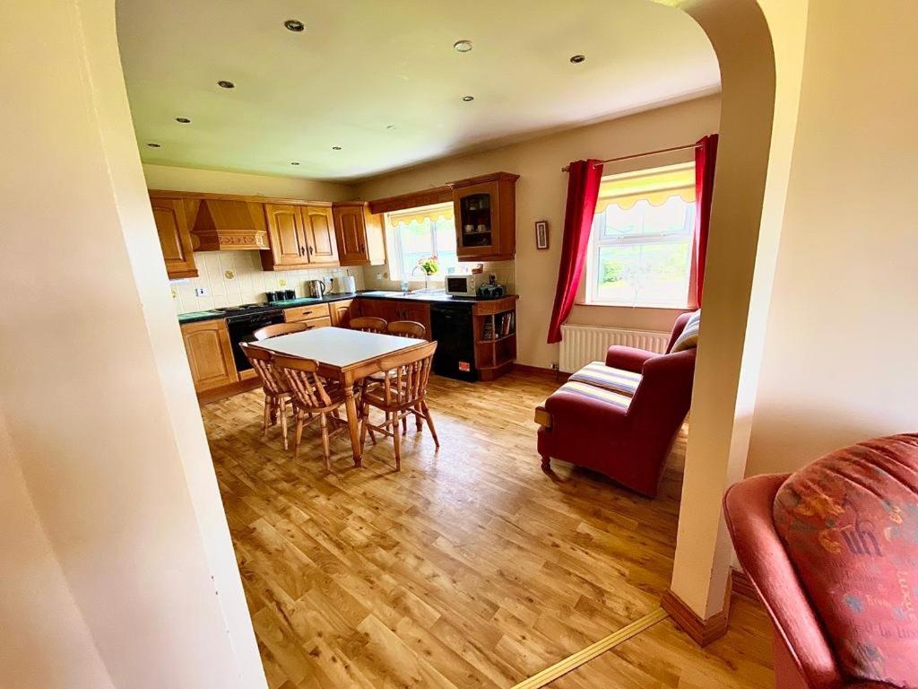 eine Küche und ein Wohnzimmer mit einem Tisch und Stühlen in der Unterkunft Quiet Farm Bungalow Enniskillen Fermanagh in Enniskillen