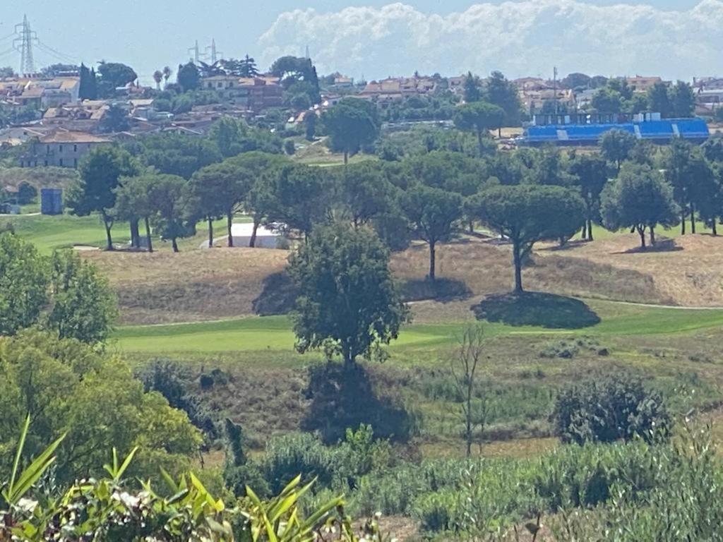 un campo da golf con alberi e un treno in lontananza di Villa Luxury con Vista Golf Club - Rider Cup a Marco Simone