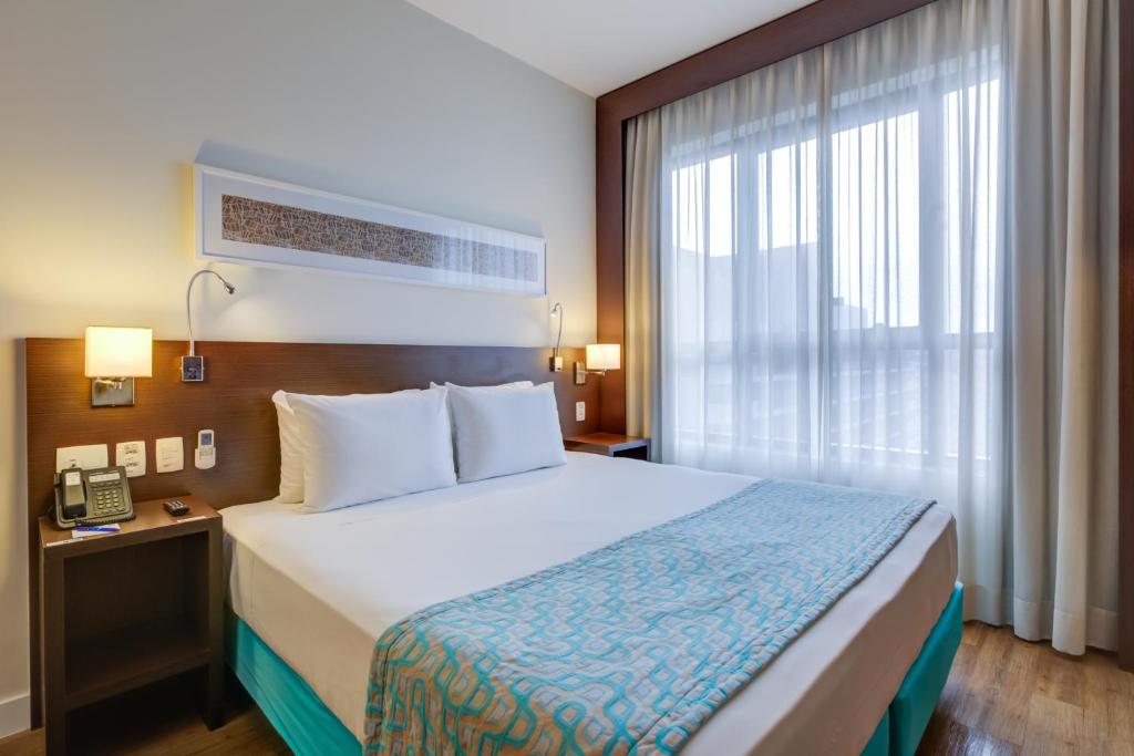 um quarto de hotel com uma cama e uma janela em Comfort Hotel São Caetano em São Caetano do Sul