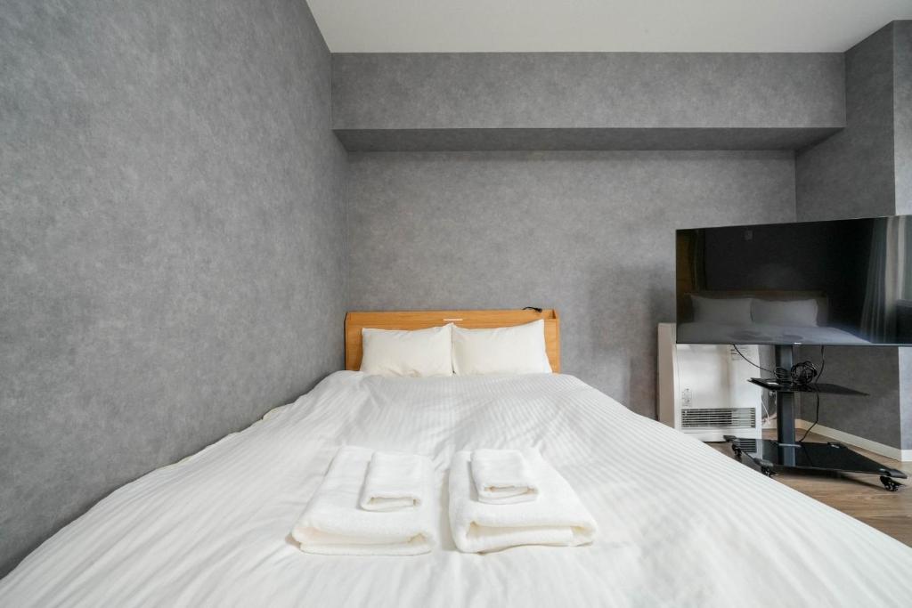 una camera da letto con un letto e due asciugamani di Residence Hotel KABUTO - Vacation STAY 46143v a Sapporo