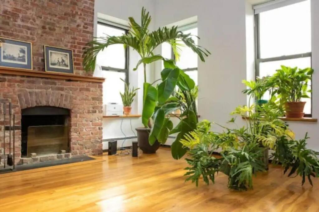 a living room with plants and a brick fireplace at Unique 1BR Greenwich Penthouse Escape! in New York