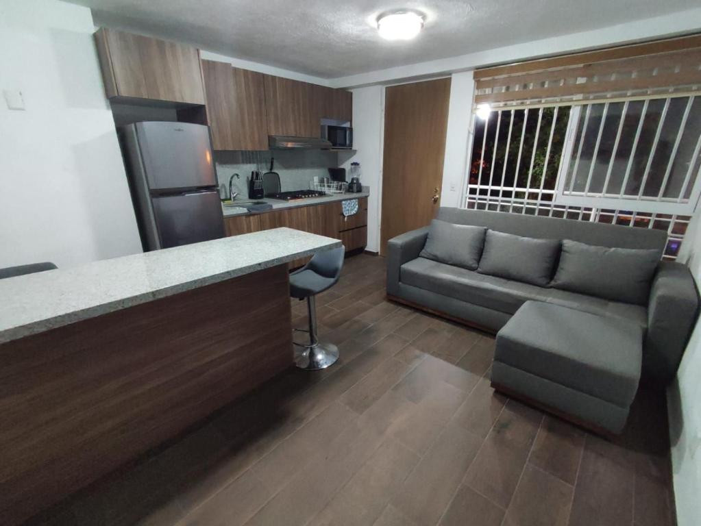 cocina y sala de estar con sofá y mesa en Departamento cerca de zoológico y estadio Jalisco en Guadalajara