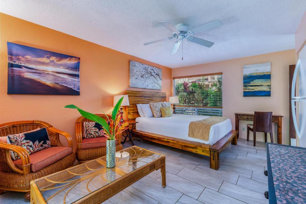 a bedroom with a bed and a couch and a table at Hideaway Haven Suite in Princeville
