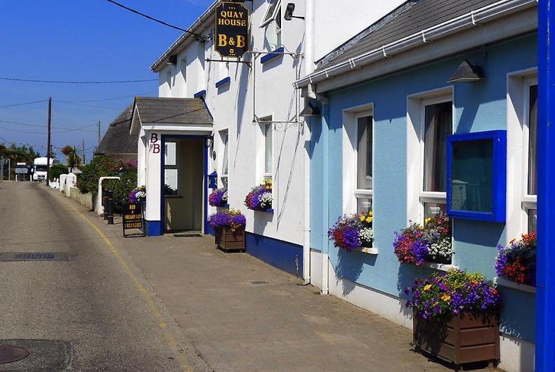 ein blau-weißes Gebäude mit Blumen in den Fenstern in der Unterkunft Quay House in Wexford