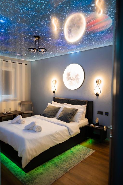 a bedroom with a large bed with planets and lights at Relaxveld Galaxy in Curtea de Argeş