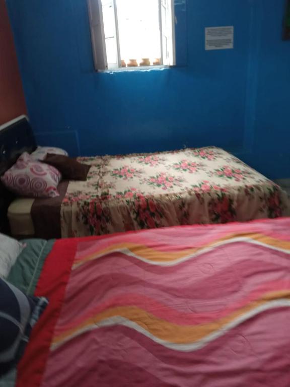 a blue room with a bed with a colorful blanket at HOTEL EL PANECILLO-Tanta in Quito