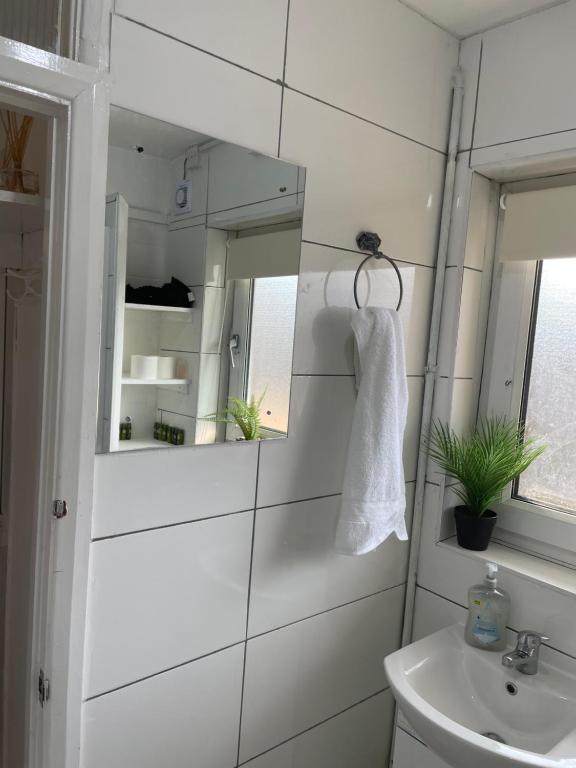 a white bathroom with a sink and a mirror at Westfield apartment in London