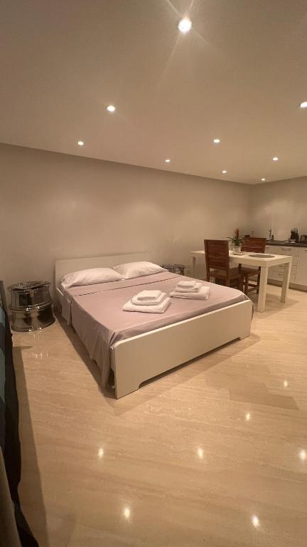 1 dormitorio con cama blanca y mesa en CUORE OPENSPACE, en Morcote
