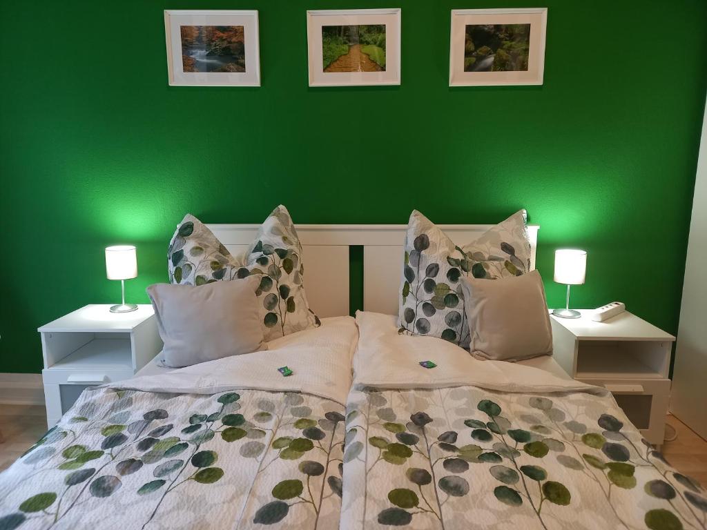 a green bedroom with a bed and two night stands at Ferienwohnung Xenia in Pirna