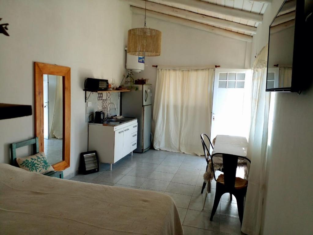 a bedroom with a bed and a desk and a kitchen at Departamentos Fabio in Federación
