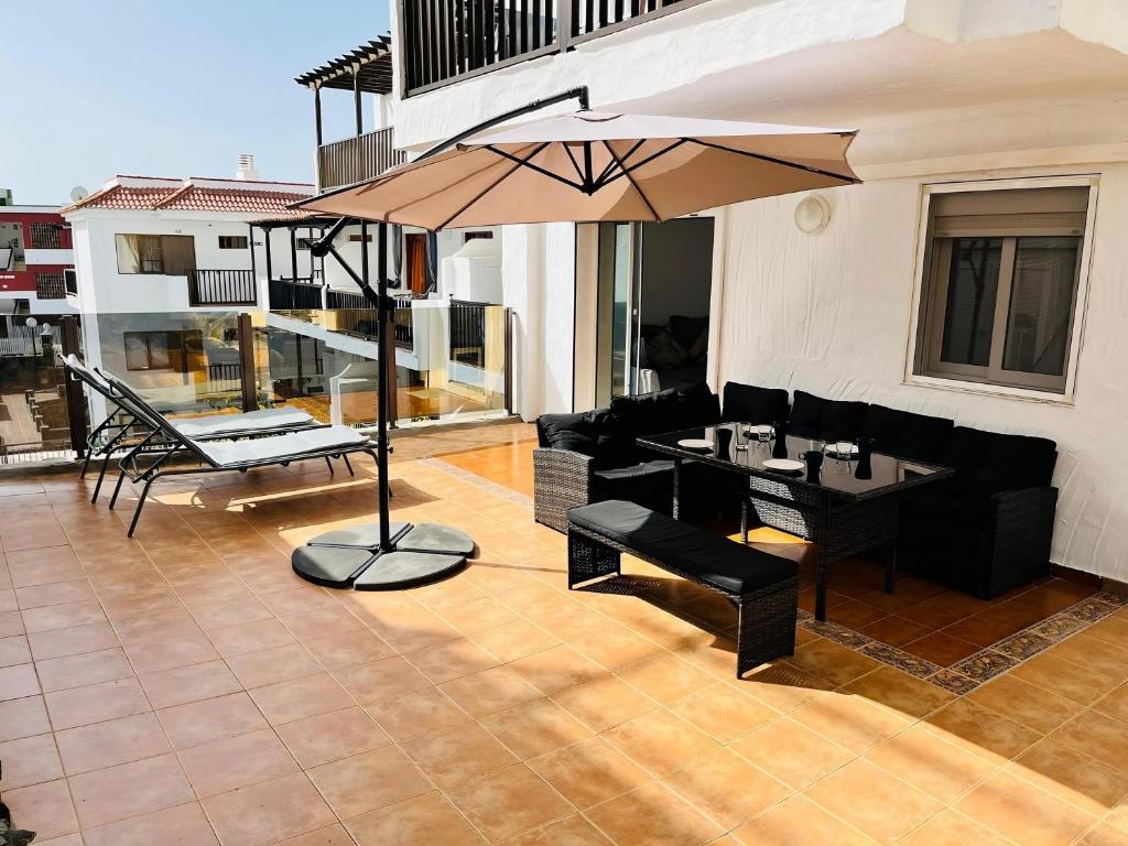 a patio with a table and an umbrella at Refugio en el Mar in San Agustin