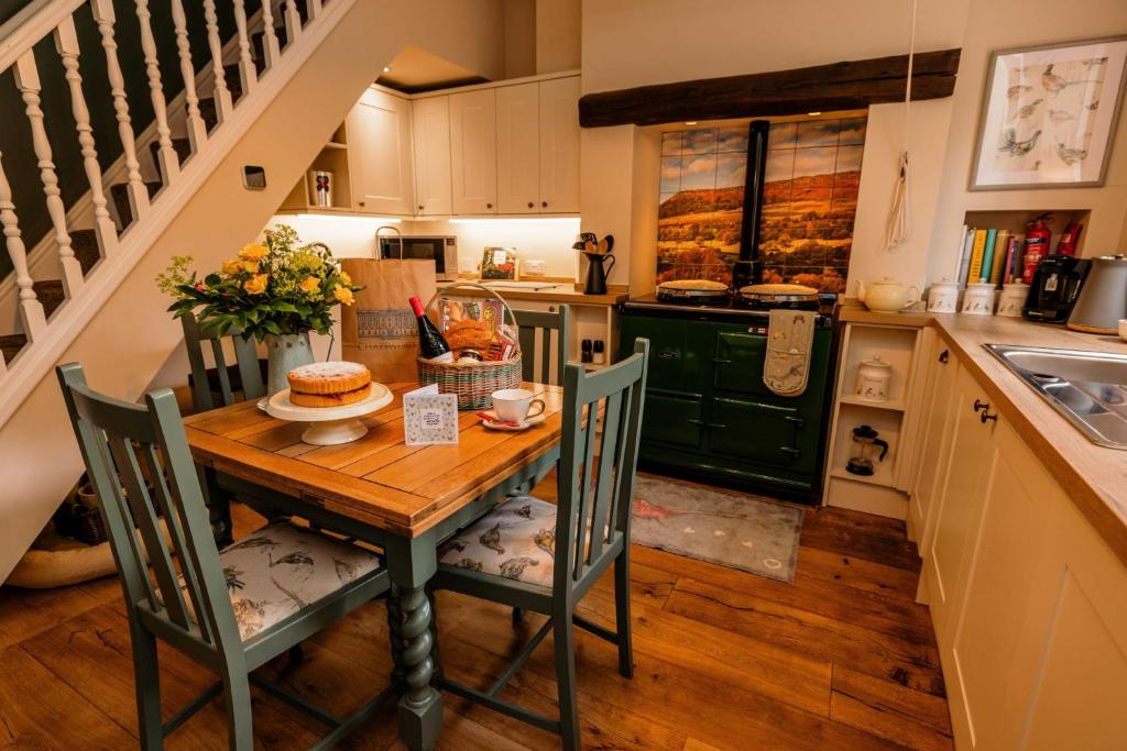 uma cozinha com uma mesa com um bolo em George's Cottage em Bamford