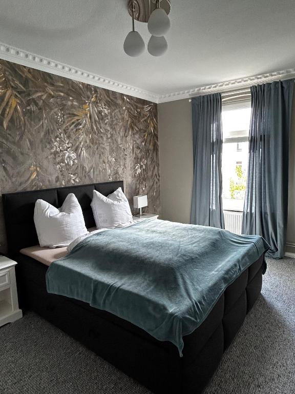 1 dormitorio con 1 cama grande con manta azul en Traumhafter Altbaucharme in zentraler Lage en Kiel