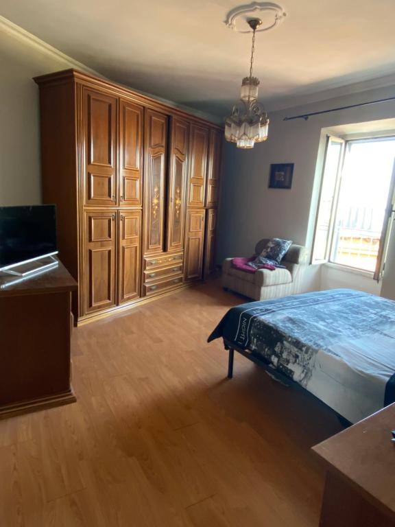 Schlafzimmer mit einem Bett, Holzschränken und einem Fenster in der Unterkunft Casa Livia in Genzano di Roma