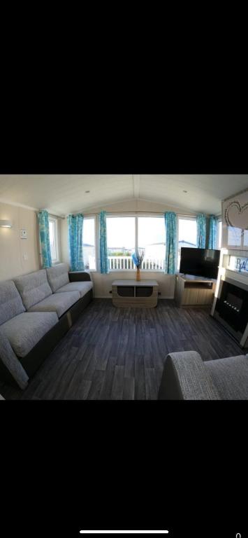 a large living room with a couch and a television at 87 kyntyre view Craig tara in Ayr